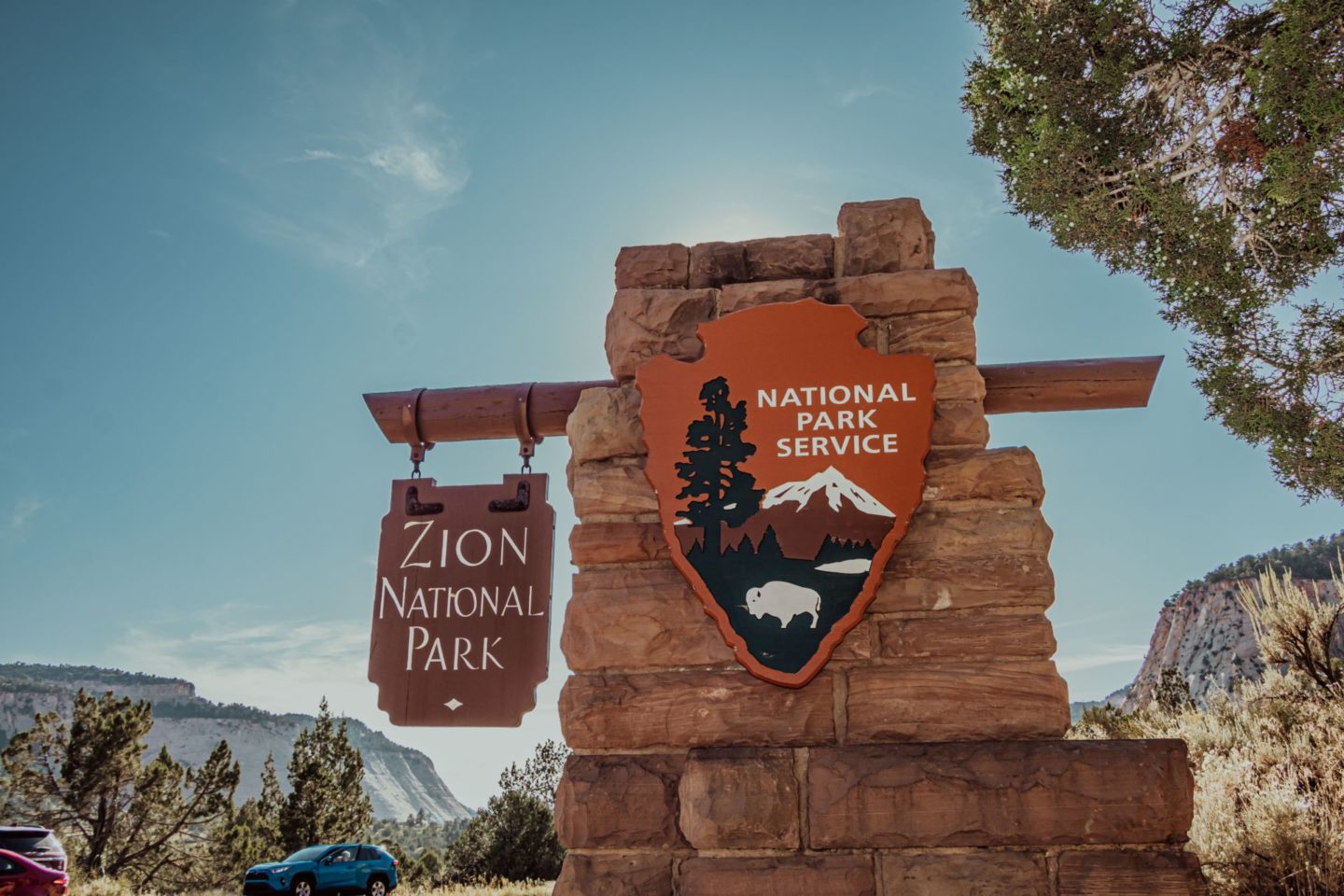 Zion National Park entrance sign by the National Park Service. Enter the park for $30 or use your America The Beautiful Pass.